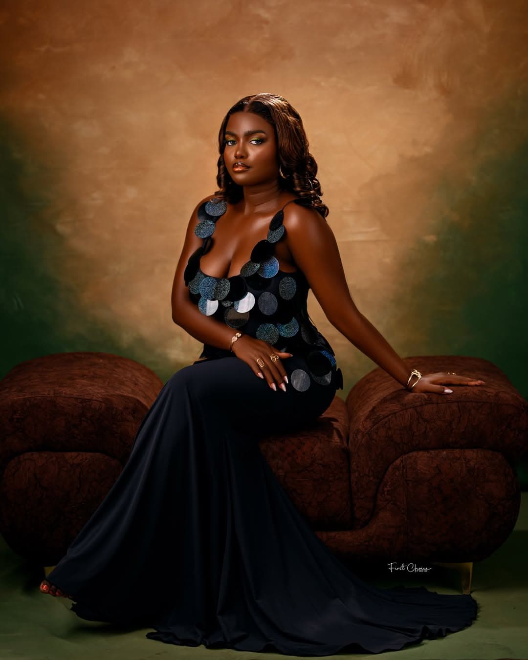 Studio portrait in a black gown with seated pose