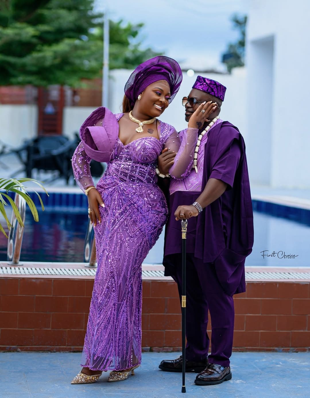 Couple in matching purple aso-oke by poolside
